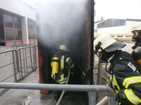 Atemschutzgeräteträger beim Vorgehen in einen Brandübungscontainer