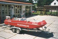 das ehemalige Mehrzweckboot steht auf dem Bootsanhänger vor dem Feuerwehrgerätehaus