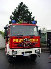 Das LF16 in Frontalansicht mit Blumenschmuck auf der Motorklappe